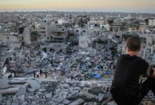 A young child sitting on the rubble of a destroyed house in Gaza. Photo by Ibrahim Khader/ Pacific Press/ Light Rocket via Amnesty International via Getty Images.