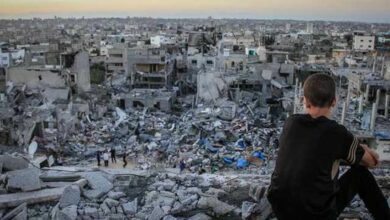 A young child sitting on the rubble of a destroyed house in Gaza. Photo by Ibrahim Khader/ Pacific Press/ Light Rocket via Amnesty International via Getty Images.